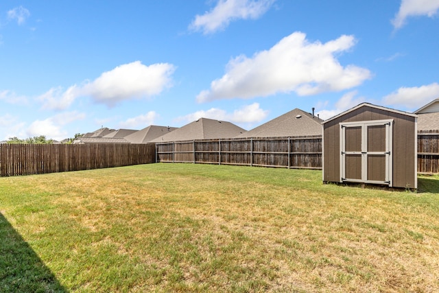 view of yard with a storage shed, a fenced backyard, and an outdoor structure