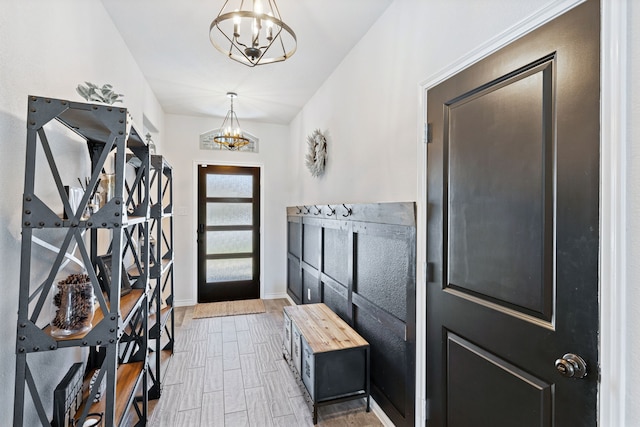 interior space with wood finished floors, baseboards, and an inviting chandelier