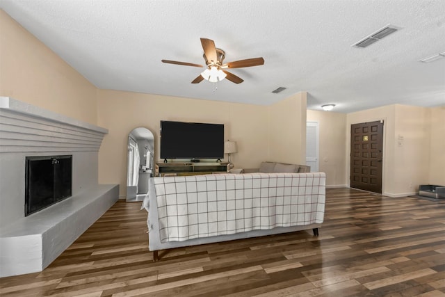 living room with ceiling fan, a textured ceiling, and hardwood / wood-style floors