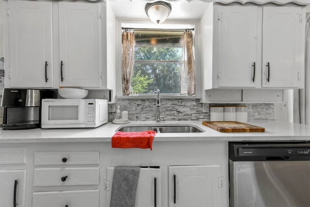 kitchen with white cabinetry, stainless steel dishwasher, sink, and backsplash