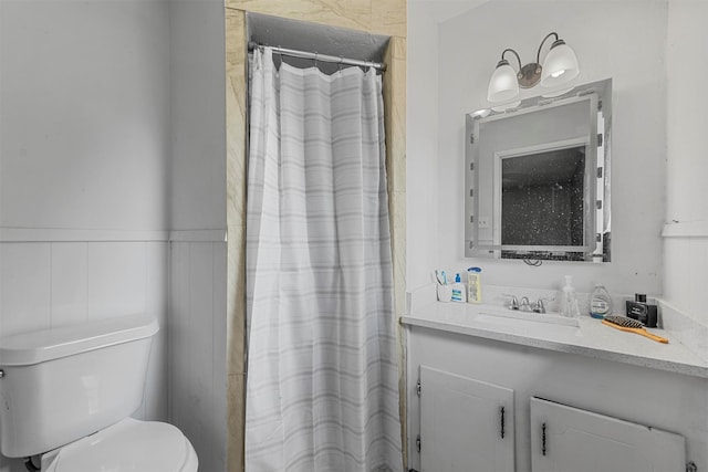 bathroom featuring toilet, a shower with shower curtain, and vanity