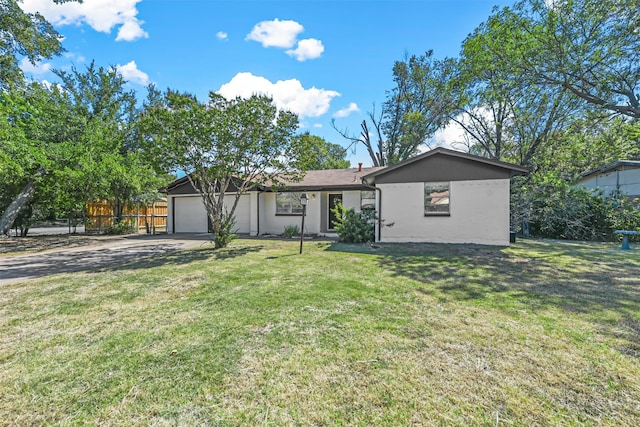 ranch-style home with a garage and a front lawn