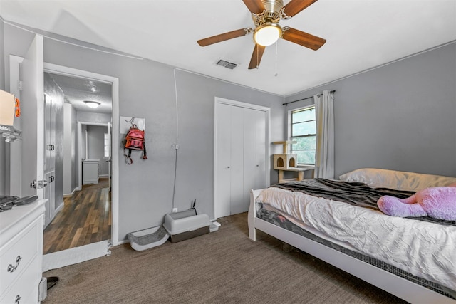 carpeted bedroom with ceiling fan and a closet