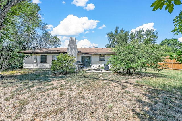 back of property featuring a patio and a lawn