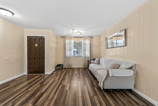 living room featuring dark wood-type flooring and a textured ceiling