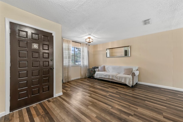 entryway featuring dark wood-type flooring and a textured ceiling