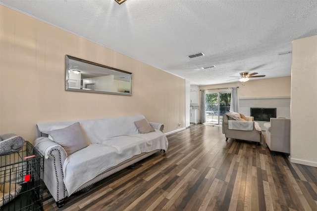 living room with hardwood / wood-style floors, a textured ceiling, and ceiling fan