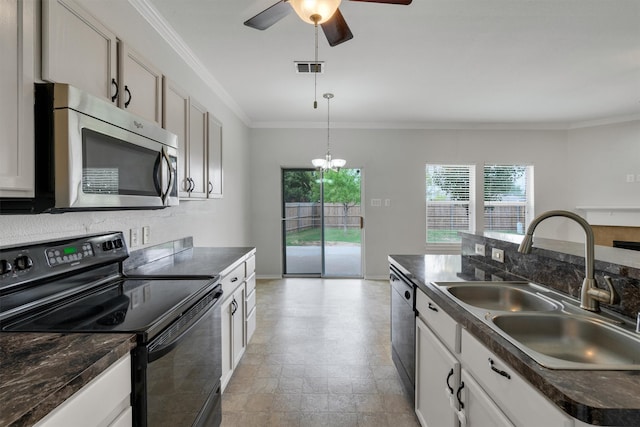 kitchen featuring pendant lighting, sink, ornamental molding, an island with sink, and appliances with stainless steel finishes