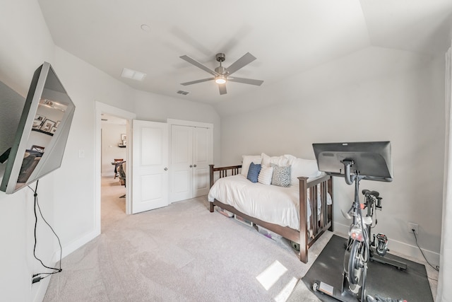 bedroom featuring ceiling fan, a closet, lofted ceiling, and light carpet