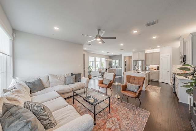 living room featuring ceiling fan, sink, and wood-type flooring