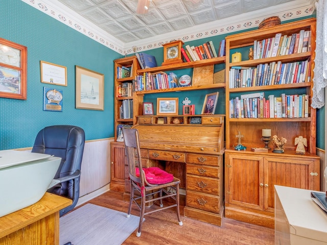 office area featuring light wood-style flooring, wainscoting, an ornate ceiling, and wallpapered walls