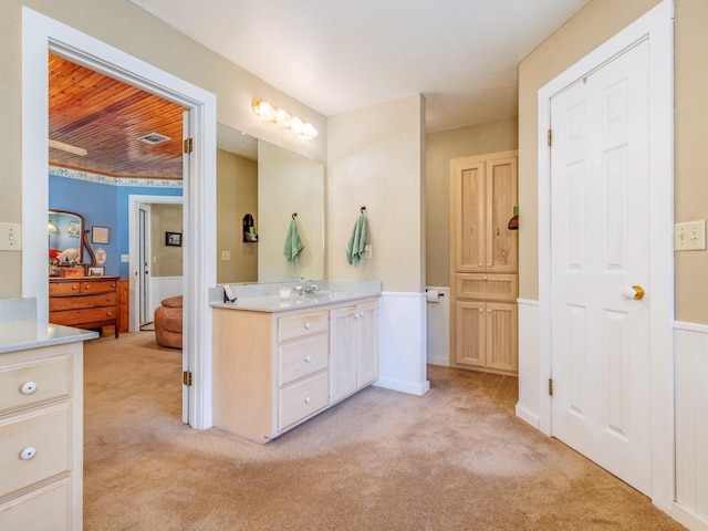 ensuite bathroom with ensuite bathroom, carpet flooring, and vanity