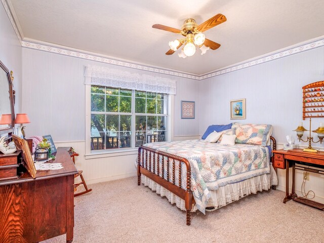 bedroom with ceiling fan, ornamental molding, and light colored carpet