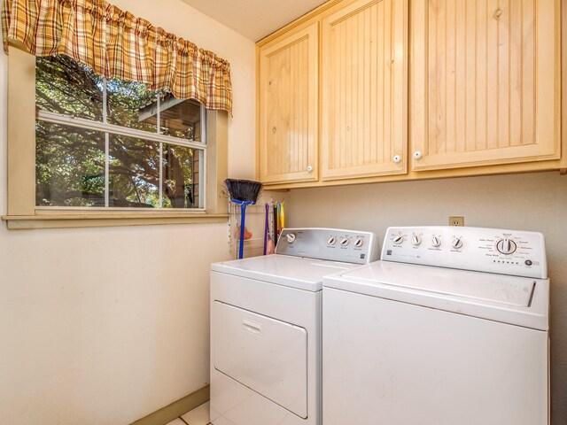 washroom with washer and clothes dryer and cabinets