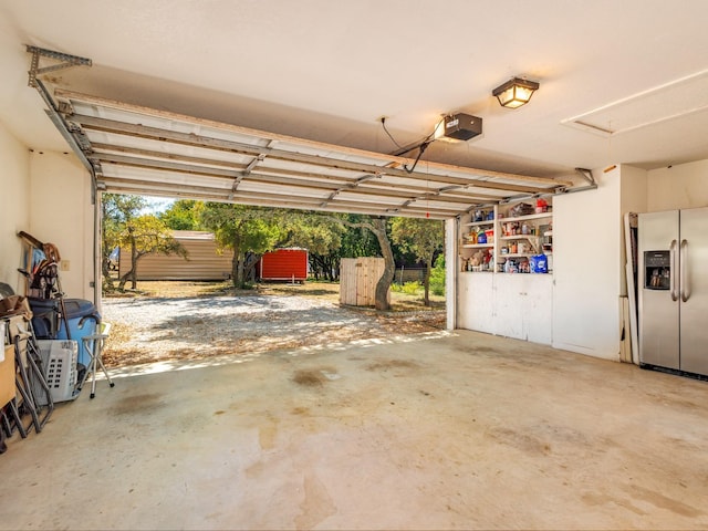 garage featuring a garage door opener and stainless steel fridge with ice dispenser