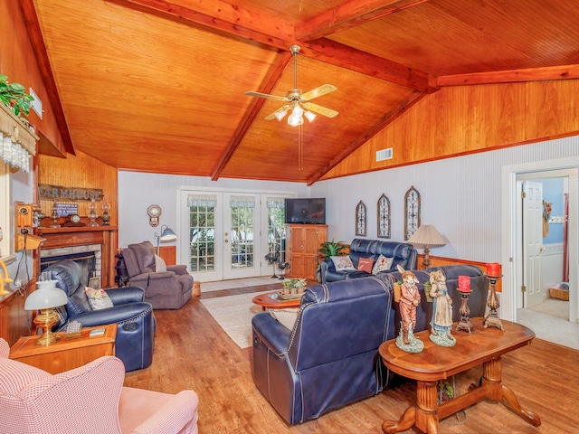 living room with ceiling fan, french doors, light hardwood / wood-style floors, and lofted ceiling with beams