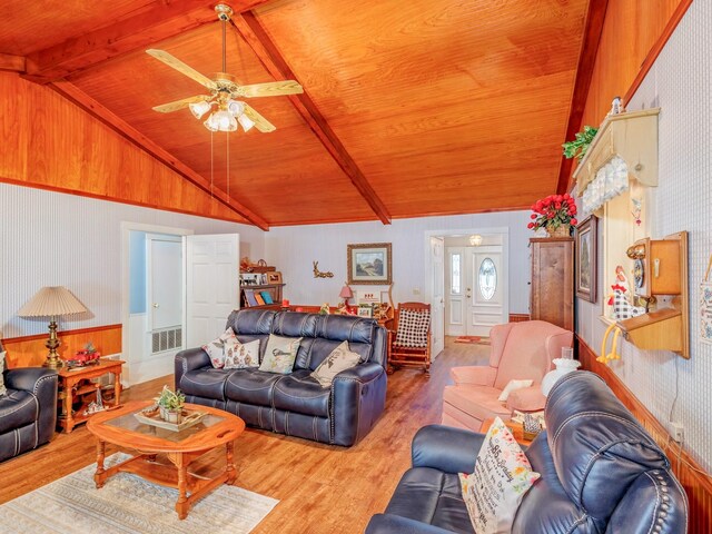 living room featuring ceiling fan, vaulted ceiling with beams, wooden ceiling, and hardwood / wood-style flooring