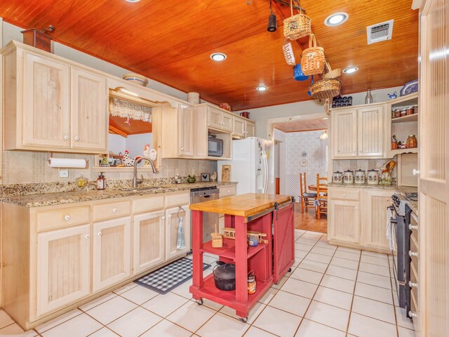 kitchen featuring light tile patterned flooring, appliances with stainless steel finishes, and decorative backsplash