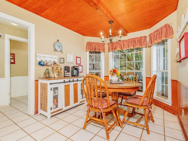 tiled dining room featuring beam ceiling, wood ceiling, and a chandelier