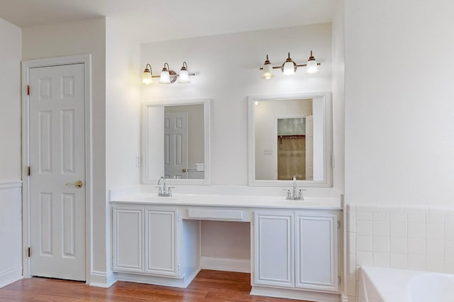 bathroom with hardwood / wood-style flooring, a bathtub, and vanity