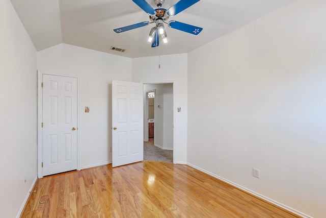 unfurnished bedroom featuring ceiling fan, vaulted ceiling, and light hardwood / wood-style flooring