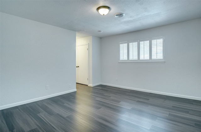 unfurnished room with a textured ceiling and dark wood-type flooring