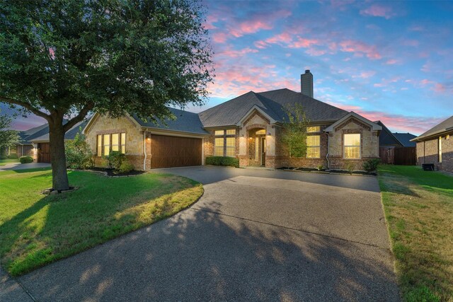 view of front facade with a lawn and a garage