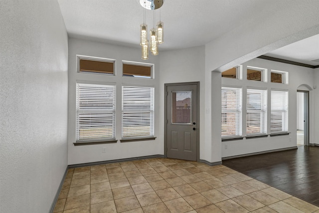 foyer entrance with light wood-type flooring, an inviting chandelier, and crown molding