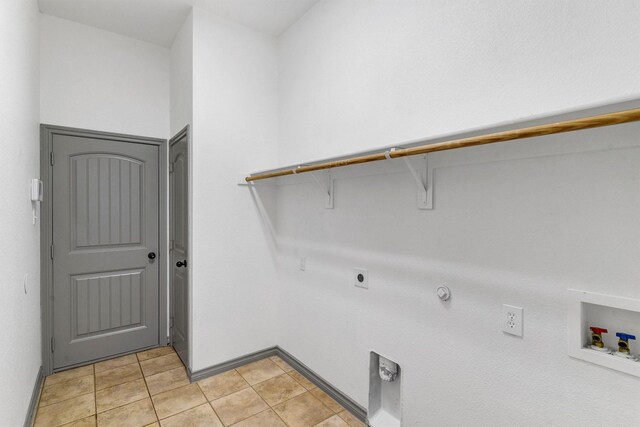 clothes washing area featuring washer hookup, gas dryer hookup, light tile patterned flooring, and electric dryer hookup