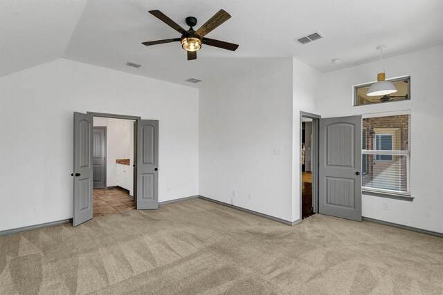 unfurnished bedroom with ceiling fan, vaulted ceiling, and light tile patterned flooring