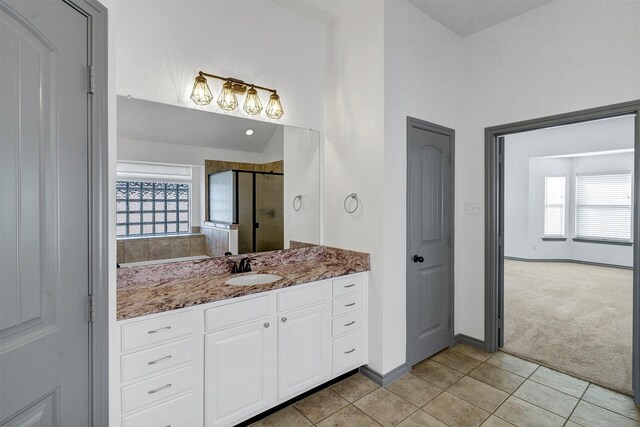 bathroom featuring walk in shower, tile patterned flooring, and vanity