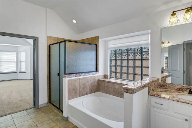 bathroom with vaulted ceiling, tile patterned floors, vanity, and a healthy amount of sunlight