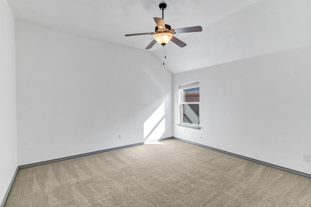 spare room featuring ceiling fan, light carpet, and lofted ceiling