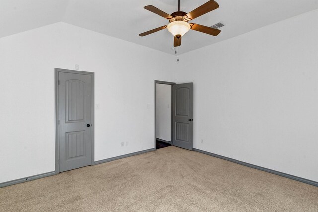 spare room featuring ceiling fan, vaulted ceiling, and light colored carpet