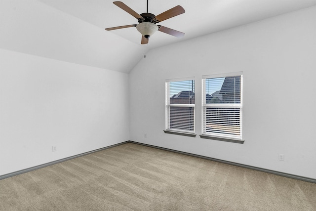 carpeted empty room featuring ceiling fan and lofted ceiling