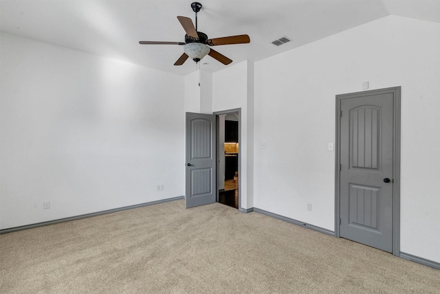 unfurnished bedroom with ceiling fan, vaulted ceiling, and light carpet