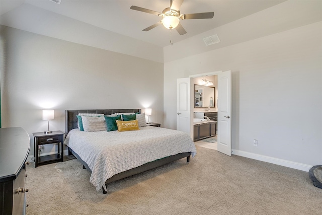 bedroom featuring ceiling fan, light carpet, and ensuite bath