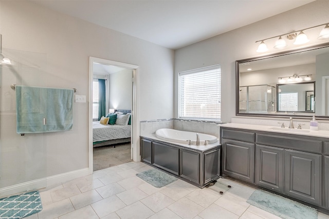 bathroom featuring tile patterned flooring, vanity, and a tub to relax in