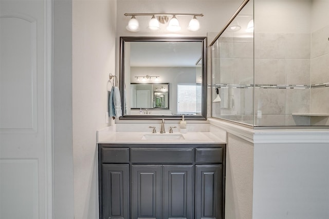 bathroom with a tile shower and vanity