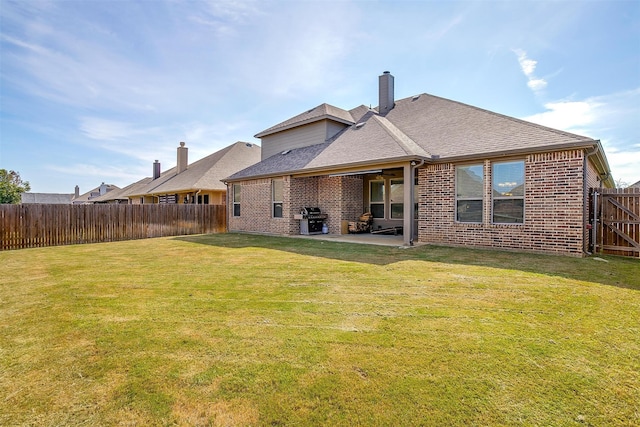 back of property with a lawn and a patio