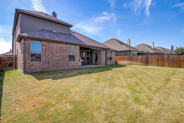 rear view of property featuring a patio and a yard