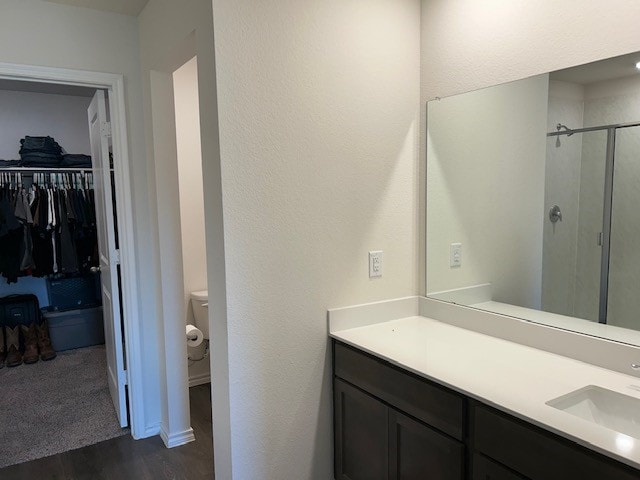 bathroom with hardwood / wood-style floors, an enclosed shower, and vanity