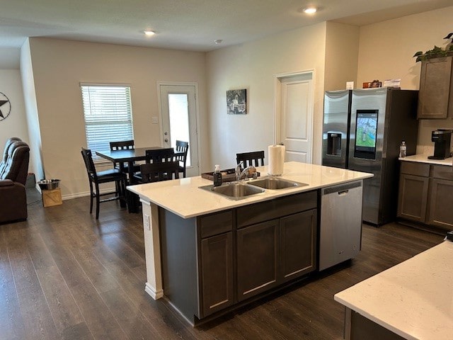 kitchen featuring stainless steel appliances, dark hardwood / wood-style floors, and a kitchen island with sink