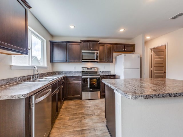 kitchen with visible vents, appliances with stainless steel finishes, dark brown cabinets, and a sink