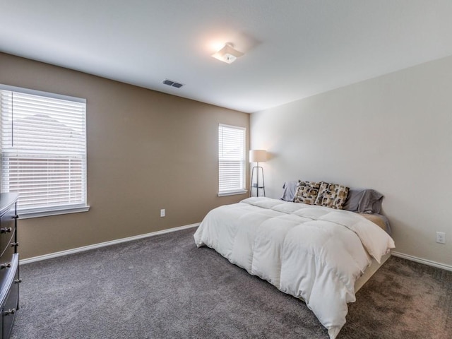 carpeted bedroom with visible vents and baseboards