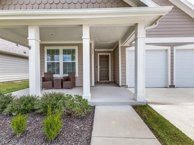 property entrance with an attached garage, covered porch, and concrete driveway