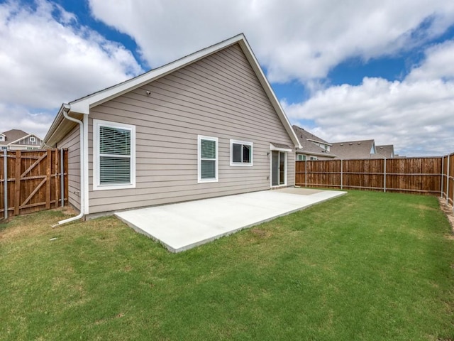 rear view of house featuring a patio area, a lawn, and a fenced backyard