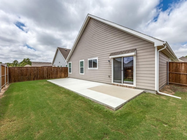 back of property with a fenced backyard, a lawn, and a patio