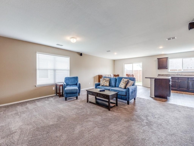 living room featuring carpet, visible vents, baseboards, and recessed lighting