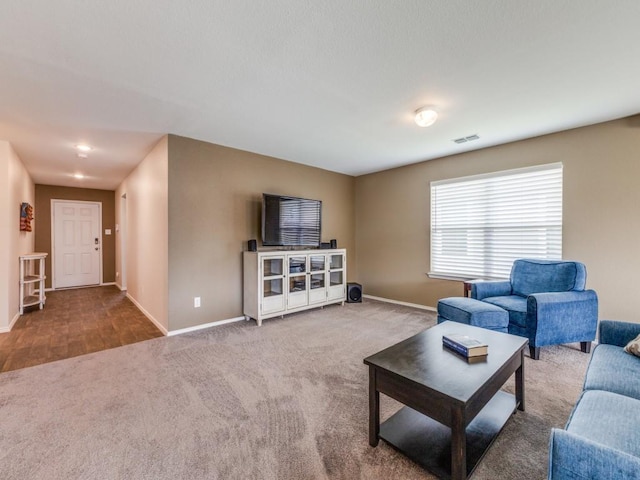 living area featuring carpet floors, visible vents, and baseboards